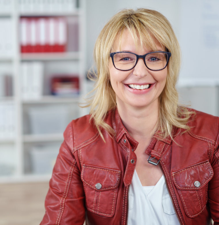 Lächelnde Frau in roter Lederjacke – steht für berufstätige Frauen, die finanzielle Unabhängigkeit anstreben.